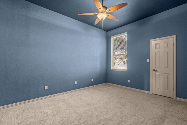 carpeted empty room featuring ceiling fan