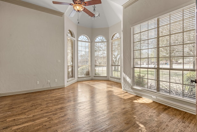 empty room featuring ceiling fan, vaulted ceiling, and hardwood / wood-style flooring