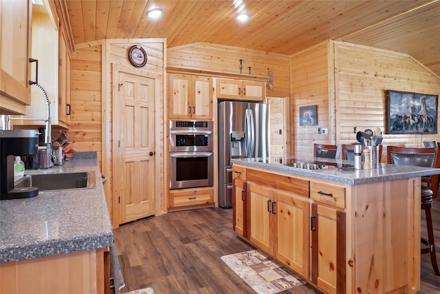 kitchen with wood walls, wooden ceiling, appliances with stainless steel finishes, a kitchen island, and a breakfast bar