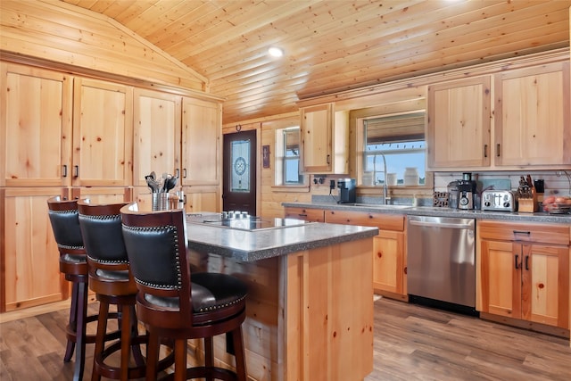 kitchen featuring light brown cabinets, a kitchen breakfast bar, lofted ceiling, stainless steel dishwasher, and a center island