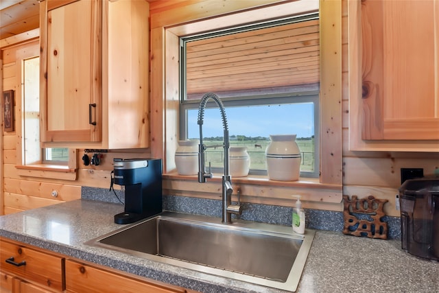 kitchen with a wealth of natural light, wooden walls, and sink