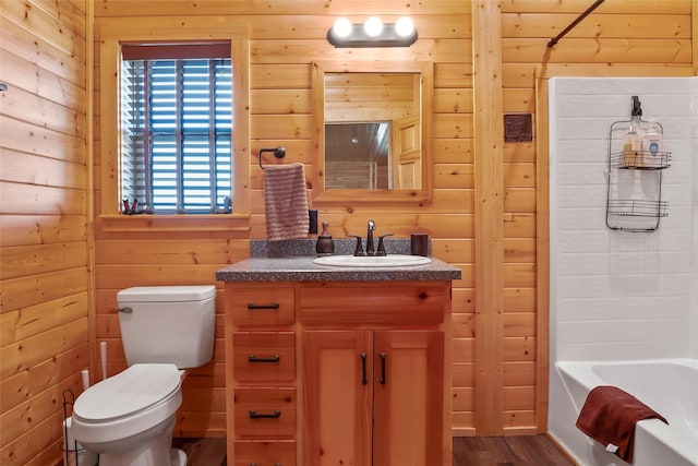 full bathroom featuring toilet, wooden walls, bathtub / shower combination, wood-type flooring, and vanity