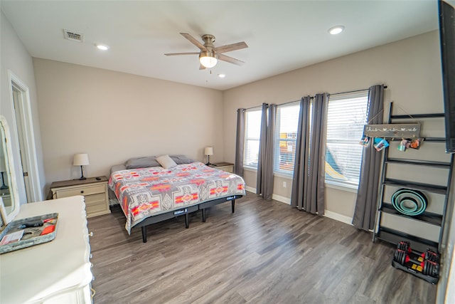 bedroom with ceiling fan, multiple windows, and dark hardwood / wood-style floors