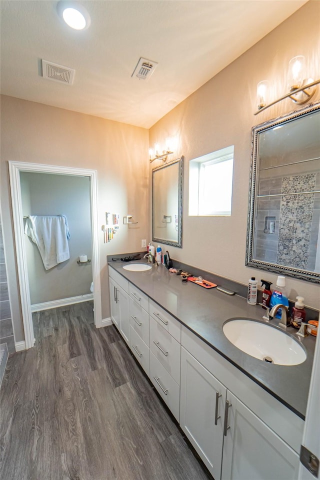 bathroom with toilet, vanity, a shower, and hardwood / wood-style flooring