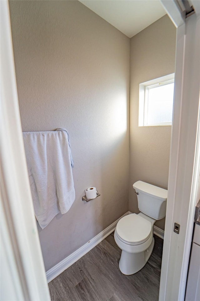 bathroom with hardwood / wood-style flooring and toilet