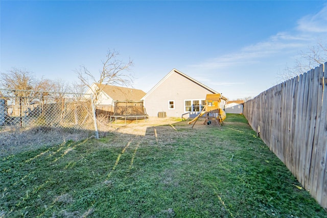 view of yard with a playground and a trampoline