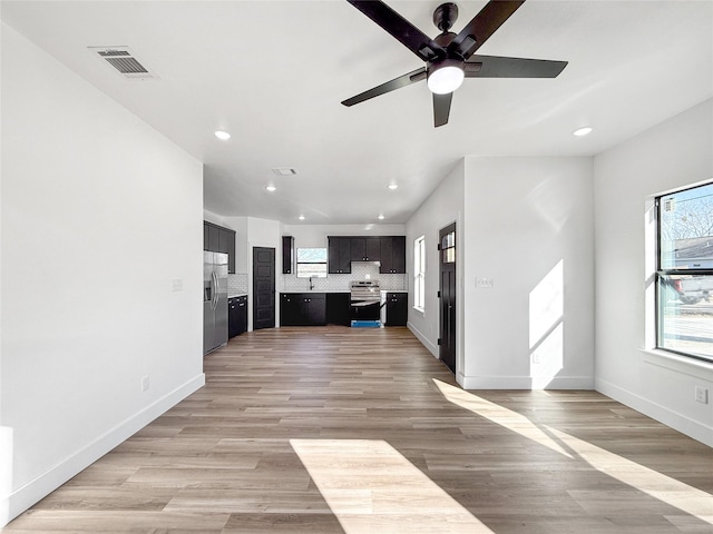 unfurnished living room featuring ceiling fan and light wood-type flooring