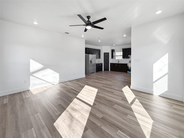 unfurnished living room with ceiling fan and wood-type flooring