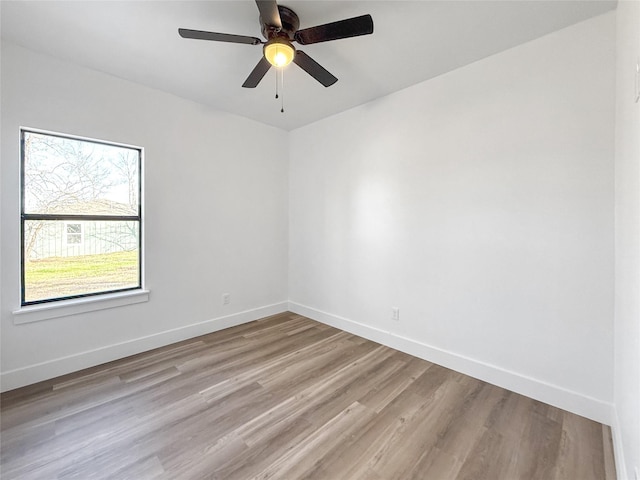 spare room with ceiling fan, a wealth of natural light, and light hardwood / wood-style flooring