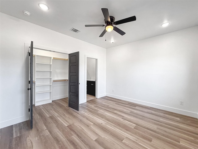 unfurnished bedroom featuring ceiling fan, a closet, and light wood-type flooring