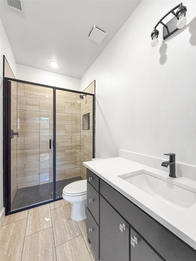 bathroom with toilet, vanity, and walk in shower