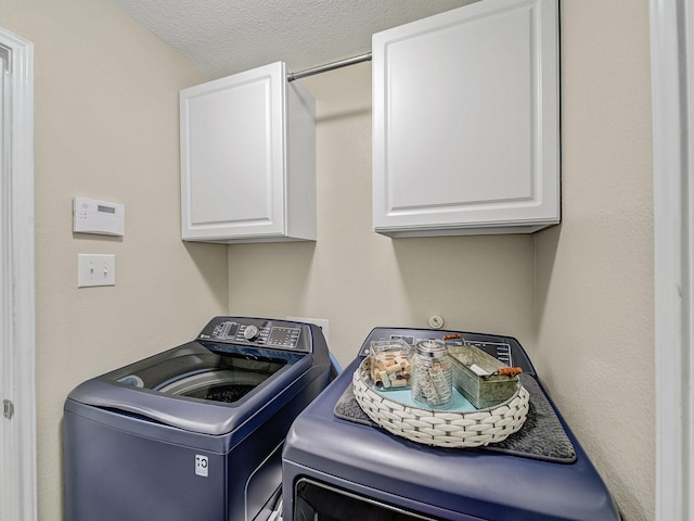 laundry area with cabinets, independent washer and dryer, and a textured ceiling