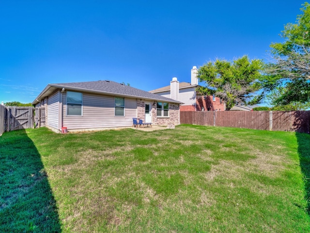 back of house with a lawn and a patio