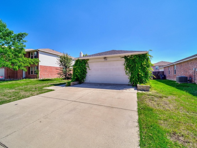 ranch-style home with a garage, cooling unit, and a front lawn