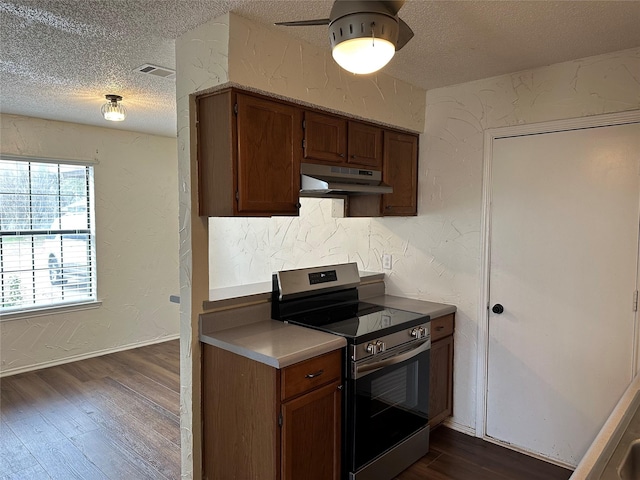 kitchen featuring ceiling fan, a textured ceiling, dark hardwood / wood-style flooring, and stainless steel electric range oven