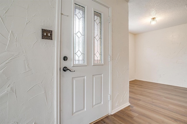 entrance foyer with a textured ceiling and light wood-type flooring