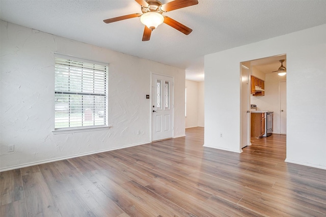 unfurnished room featuring ceiling fan, a textured ceiling, and light hardwood / wood-style floors