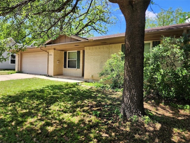 ranch-style home with a garage, a front yard, brick siding, board and batten siding, and concrete driveway