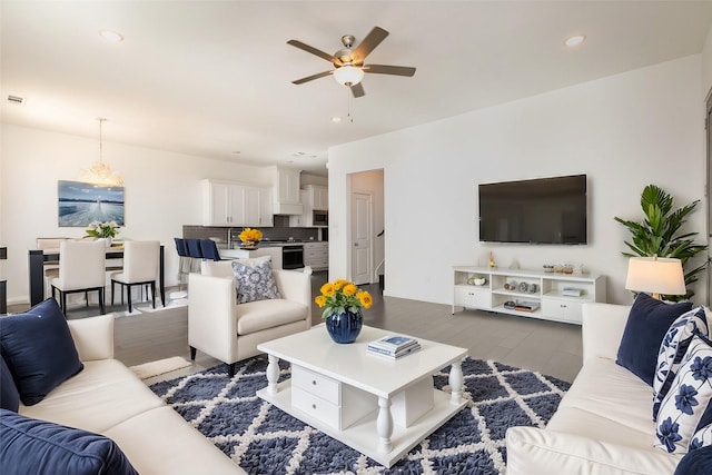 living room with ceiling fan and dark hardwood / wood-style floors