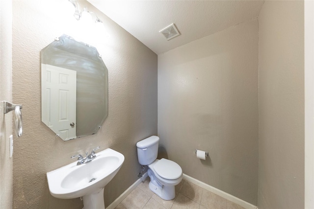 bathroom featuring toilet, tile patterned flooring, and sink