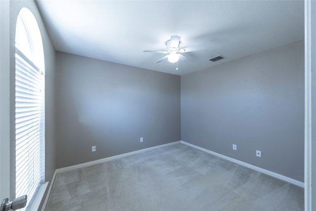 empty room featuring ceiling fan and carpet