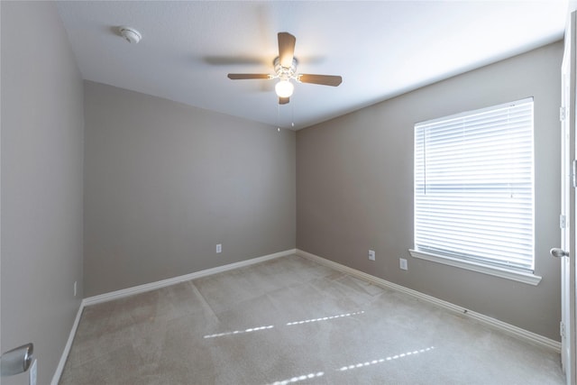 carpeted spare room with ceiling fan