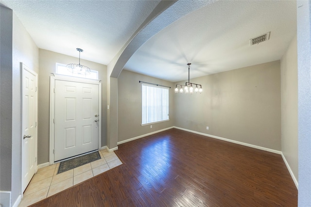 foyer with a textured ceiling and light hardwood / wood-style flooring