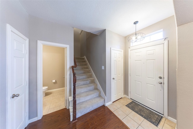 foyer entrance with an inviting chandelier and light tile patterned flooring