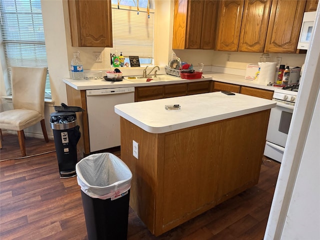 kitchen with dark hardwood / wood-style flooring, sink, white appliances, and a kitchen island