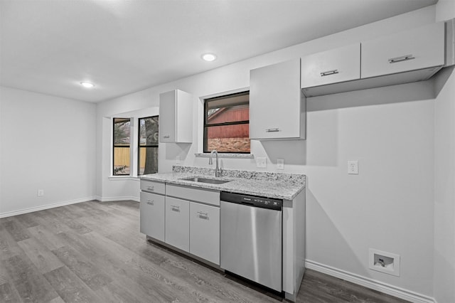 kitchen with light wood-type flooring, dishwasher, sink, and light stone counters