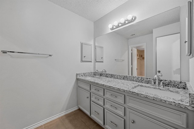 bathroom featuring vanity, tile patterned flooring, and a textured ceiling