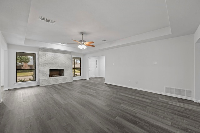 unfurnished living room with plenty of natural light, a raised ceiling, and a fireplace