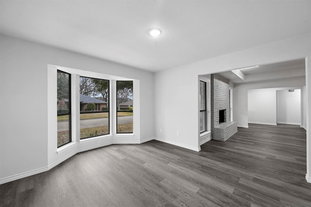 unfurnished living room with dark wood-type flooring and a fireplace