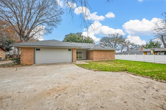 back of house featuring a garage and a yard