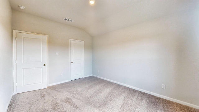 unfurnished bedroom featuring light carpet and vaulted ceiling