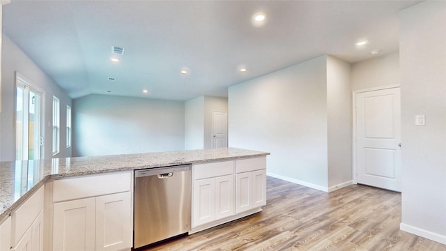 kitchen featuring lofted ceiling, stainless steel dishwasher, white cabinetry, light hardwood / wood-style flooring, and light stone countertops