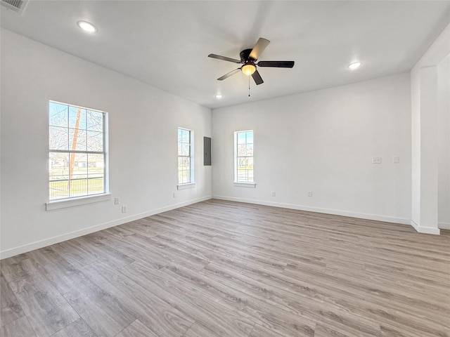 spare room with light hardwood / wood-style floors, ceiling fan, and a healthy amount of sunlight