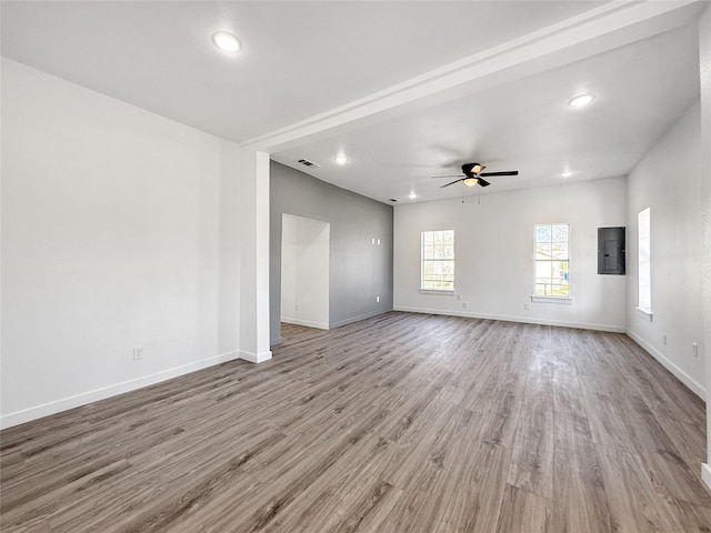 unfurnished living room with ceiling fan, electric panel, and light wood-type flooring