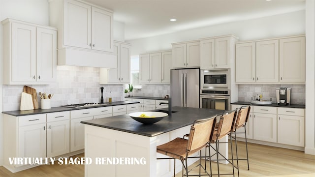 kitchen featuring a center island, a breakfast bar, white cabinetry, light wood-type flooring, and stainless steel appliances