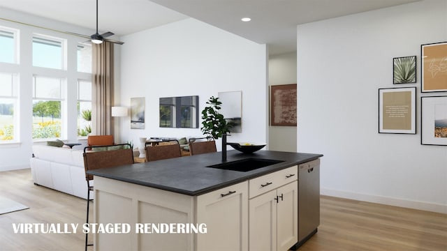 kitchen with light wood-type flooring, white cabinetry, stainless steel dishwasher, and a center island