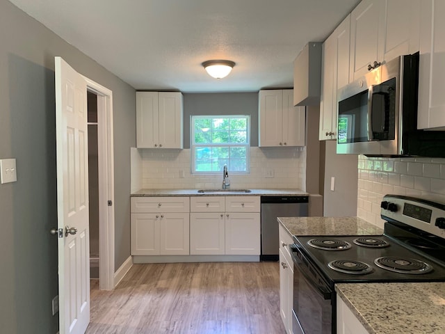 kitchen featuring tasteful backsplash, white cabinets, sink, and stainless steel appliances