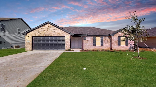 single story home with a garage, a lawn, and central air condition unit