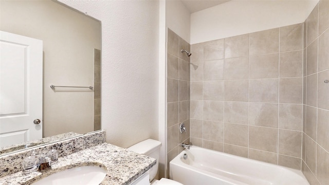 full bathroom featuring toilet, tiled shower / bath combo, and vanity