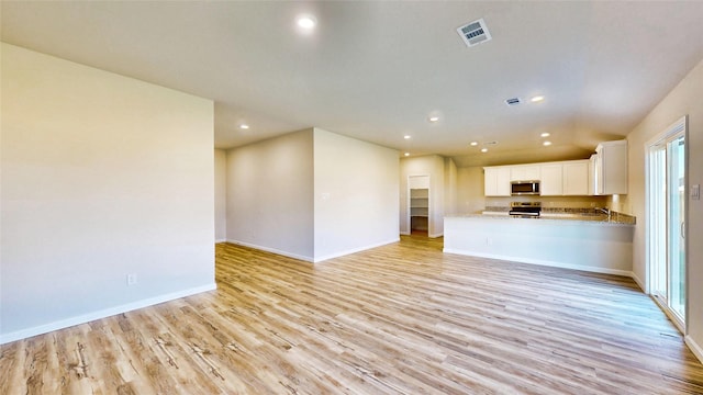 unfurnished living room featuring light hardwood / wood-style flooring and sink