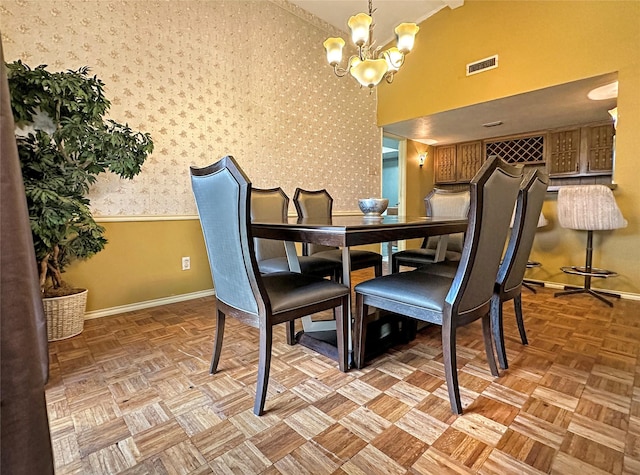 dining room with a high ceiling, light parquet floors, and a notable chandelier