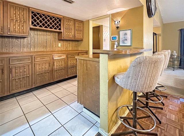 bar featuring light tile patterned flooring and wooden walls