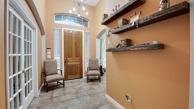 foyer entrance featuring french doors, a high ceiling, and a notable chandelier