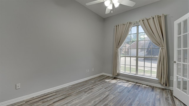 unfurnished room with lofted ceiling, ceiling fan, and wood-type flooring