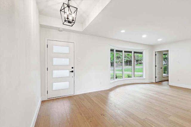 foyer with light wood-type flooring and a notable chandelier