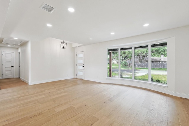 unfurnished living room with light hardwood / wood-style floors and a notable chandelier